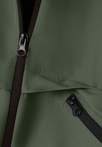 Zielona kurtka z materiału z dwoma czarnymi zamkami błyskawicznymi, jednym pionowym i jednym skosnym, przedstawiająca szczegółowe przeszycia i teksturę.