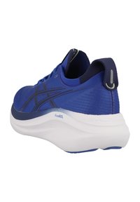 Chaussure de sport bleue avec une tige en maille, semelle blanche rembourrée et accents noirs. Comprend une languette au talon pour un enfilage facile.