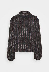 Blusa nera con motivo floreale, caratterizzata da un colletto e maniche lunghe a sbuffo. Tessuto testurizzato con righe verticali.