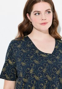 Top azul marino con mangas cortas, que presenta un estampado de limones y naranjas en amarillo y verde. Diseño de escote en forma de V con detalles de tela fruncida.
