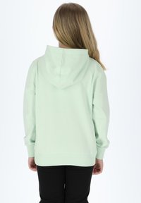 Felpa verde menta in un tessuto morbido con vestibilità comoda, dotata di cappuccio con coulisse e polsini a costine, abbinata a pantaloni neri.