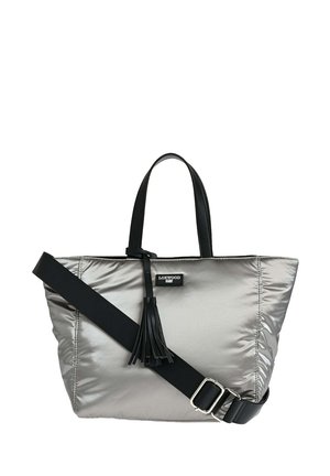 Sac fourre-tout argenté avec des poignées noires et une bandoulière réglable, arborant un pompon noir et un petit patch logo "Loxwood".