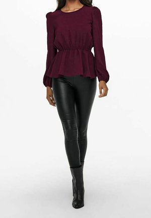 Bordowa bluzka z długim rękawem, z taliowanym krojem i rozkloszowanym dołem, zestawiona z czarnymi dopasowanymi legginsami i botkami za kostkę. Gładka faktura i prosty design.