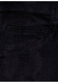 Crni denim tkanina sa vidljivom džepom, suptilnom teksturom i kontrastnim šavovima duž rubova.