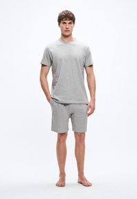 Hall halli puuvillane T-särk lühikeste varrukatega ja ümmarguse kaelusega, millele on kombineeritud sobivad hallid lühikesed püksid. Lihtne disain, särgil minimaalne bränding.