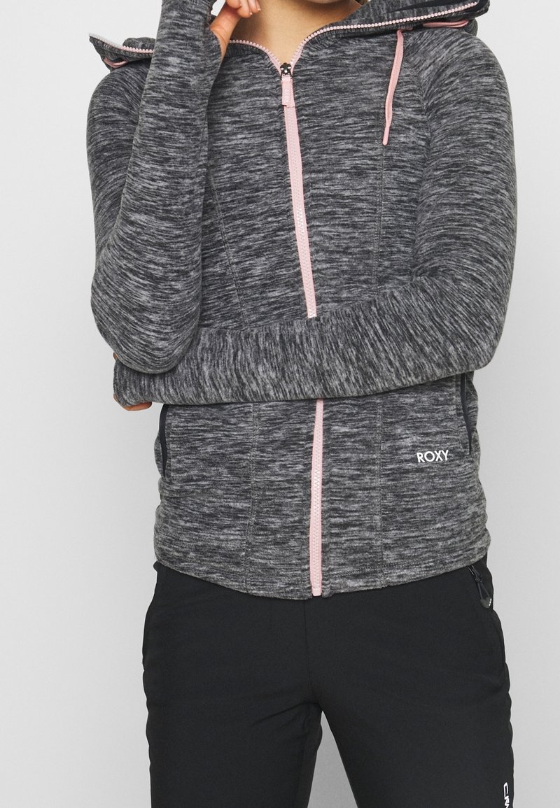Gray knit zip-up hoodie with pink zipper and drawstrings, long sleeves, and fitted design. Logo displayed on the lower front.