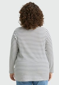 Langarmshirt mit weißen und marineblauen horizontalen Streifen, aus weichem Stoff und mit abgerundetem Saum, entworfen für eine lockere Passform.