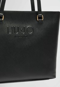 Borsa a spalla nera in similpelle con logo impresso "LIU·JO MILANO", superficie testurizzata e dettagli in metallo dorato.