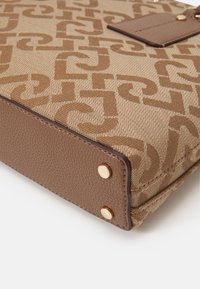 Borsa shopper marrone con motivo, con parte superiore in tessuto strutturato, base in pelle marrone liscia e dettagli in metallo color oro. Presenta una forma strutturata.