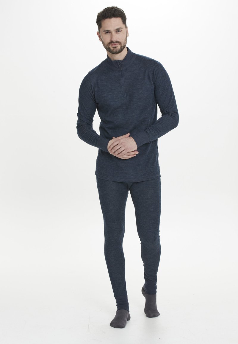 Marineblaues Thermaloberteil mit einem halben Reißverschluss-Kragen und langen Ärmeln, kombiniert mit passenden, eng anliegenden Leggings. Weiche Textur im gesamten Bereich.