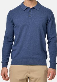 Niebieska, długosleeve'owa koszulka polo wykonana z miękkiego materiału, z kołnierzykiem, trzema guzikami oraz ściągaczami przy mankietach i u dołu.