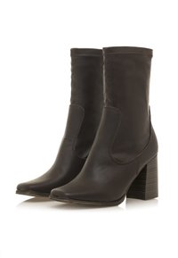 Braune Leder-Ankleboots mit einer spitz zulaufenden Zehenpartie, elastischen Seitenpanelen und einem gestapelten Absatz, die eine glatte Oberfläche und ein minimalistisches Design aufweisen.