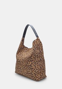 Umhängetasche im Zebra-Print aus weichem Stoff, mit einem schwarzen Ledergriff und einer entspannten, lässigen Form. Mit einem subtilen Glanz akzentuiert.
