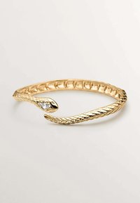 Pulsera de serpiente de oro con un diseño texturizado y trenzado, con un extremo abierto. Un extremo adornado con una gema clara. Acabado suave y pulido.