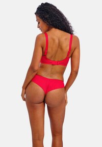 Rode lingerieset van gladde stof met verstelbare bandjes, een haak-en-oogsluiting op de bh en een scalloped rand op de onderbroek.