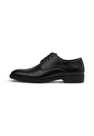 Scarpa elegante da uomo in pelle nera con allacciatura chiusa, punta liscia e tacco basso impilato, mostrata di profilo su sfondo bianco.