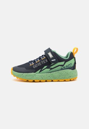 Chaussure de sport pour enfant avec semelle verte, empeigne bleu marine, semelle extérieure jaune et bride Velcro portant les mentions "PME" et "GORE-TEX" sur le côté.