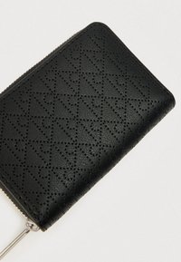 Μαύρο πορτοφόλι από υλικό συνθετικής υφής με μοτίβο διαμαντιού και ασημένιο φερμουάρ κλεισίματος.