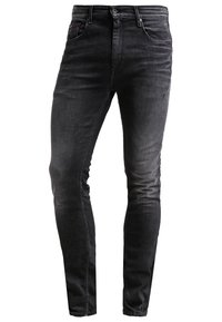 Jean noir slim avec design à cinq poches, fermeture par bouton et fermeture éclair, et légère décoloration sur les cuisses et les genoux.