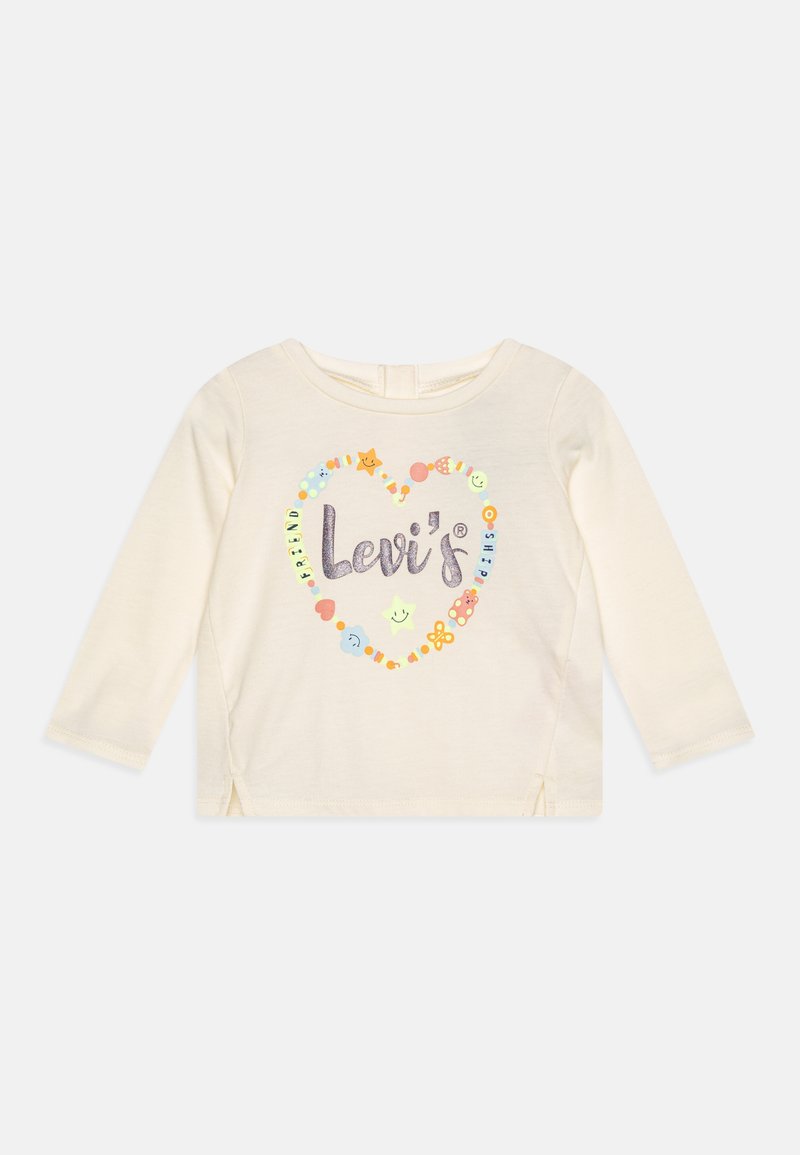 Cremekleurige top met lange mouwen, gekenmerkt door een hartvormig ontwerp met kleurrijke graphics en de tekst "Levi's" in het midden, met zijsplitten aan de onderkant.
