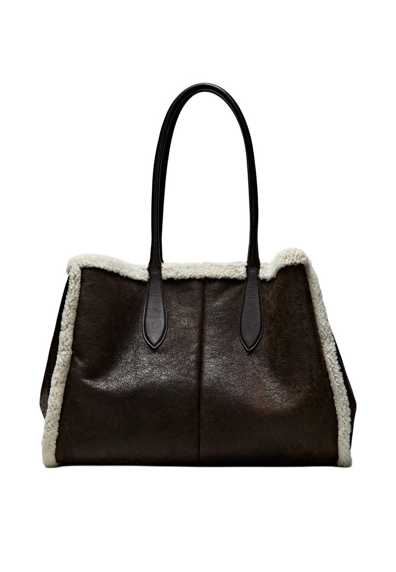 Braune Ledertasche mit weichem weißem Fleecebesatz und glatten dunkelbraunen Griffen, mit einer strukturierten Form und zwei offenen Fächern.