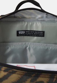 Borsa Levi's con zip, dotata di un rivestimento in plastica riciclata, design a strisce di tigre nere e marroni, e una maniglia per un facile trasporto.