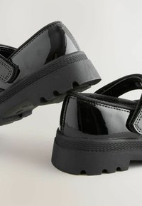 Schwarze Lacklederschuhe mit einer klobigen schwarzen Gummisohle und verstellbarem Riemen. Verfügt über eine glatte Textur und ein rundes Zehendesign.