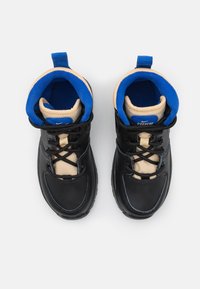 Czarne buty sportowe z beżowym i niebieskim wnętrzem, z teksturowanym wykończeniem, sznurówkami i wyraźnym logo na języku.