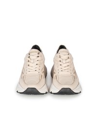 Chaussures de sport beiges avec tige en maille et cuir, bout rond et semelle plate en caoutchouc. Elles présentent des lacets et des accents texturés sur les côtés.