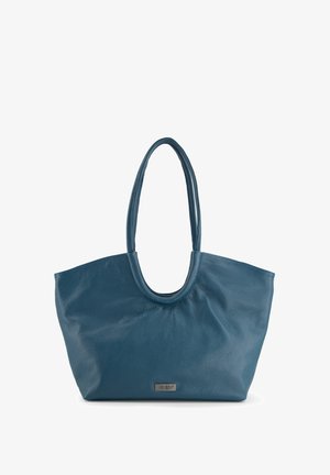 Blaue Ledertasche mit weicher Textur, abgerundetem oberen Rand und langen Griffen. Verfügt über ein kleines metallisches Logo-Schild auf der Vorderseite.