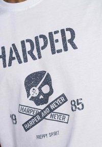 Camiseta blanca de algodón con un gran gráfico desgastado en color marino que presenta el texto "HARPER" y un diseño de calavera, junto con "HARPER AND NEYER" y "PREPPY SPIRIT."