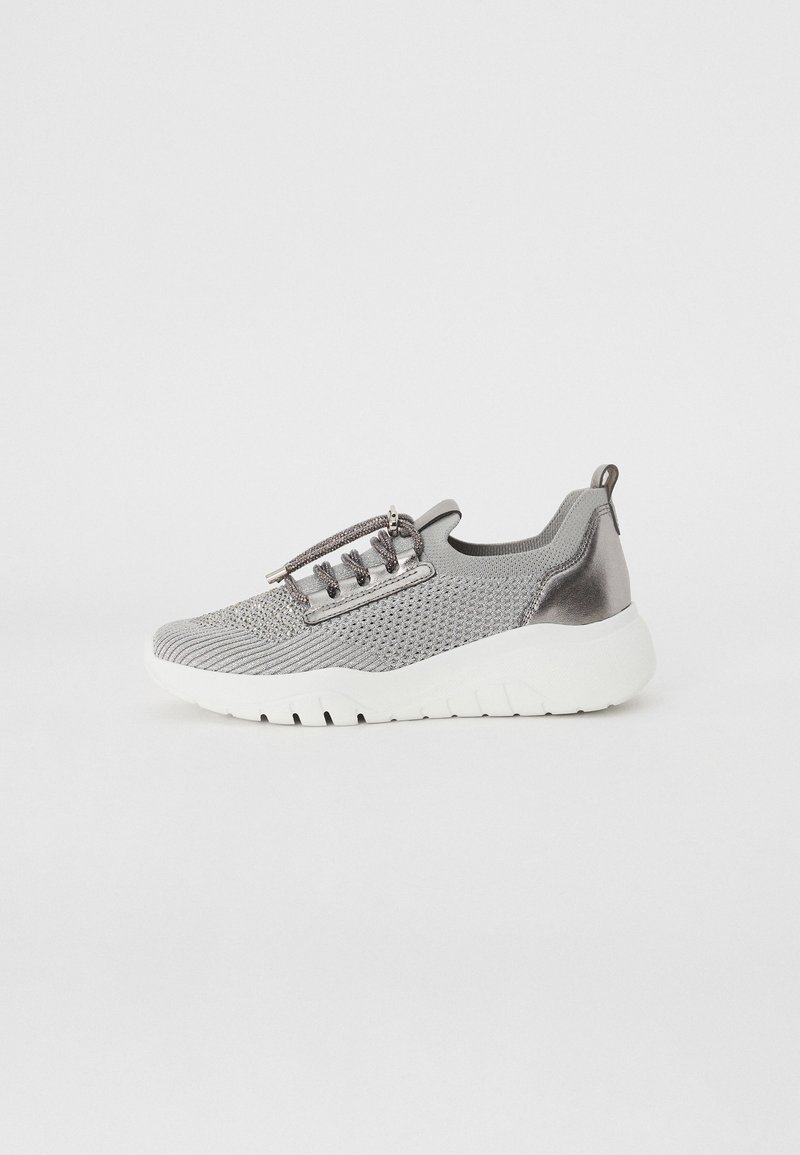 Scarpa da atletica in rete grigia con un accento metallico, lacci elastici e suola bianca. Presenta una punta arrotondata e un design testurizzato.