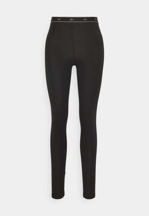 Fekete leggings, sima, rugalmas anyagból, magas derekú, logós díszítéssel, és szűkített fazonú a bokáknál.