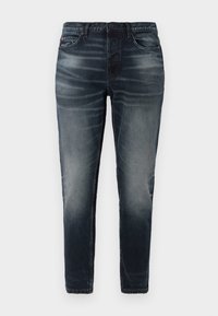 Vaqueros de mezclilla azul oscuro con corte slim, detalles desgastados, cinco bolsillos y cierre de botón. Textura suave con mínimos acentos de costura.