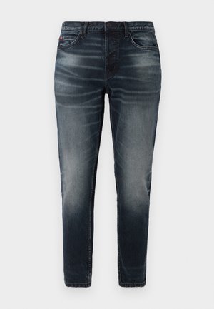 Mørkeblå denim jeans med slim fit, blegede detaljer, fem lommer og knaplukning. Glat tekstur med minimal syning.