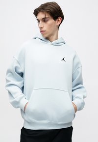 Hoodie bleu clair en tissu doux. Comprend une poche avant, des manches à poignets côtelés et un logo Jordan noir sur la poitrine gauche.