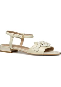 Beige läder sandal med öppen tå, ankelrem och spänne. Har en dekorativ ögla fram och en låg blockklack.