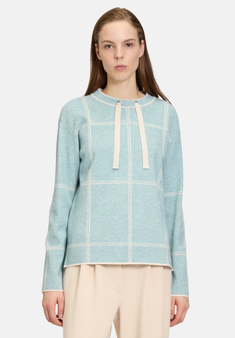 Blaues Wollmischpullover mit einem Karomuster, langen Ärmeln, einem runden Ausschnitt und zwei vorderen Bindebändern zum Verschließen.