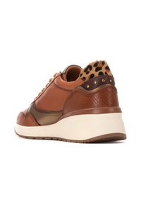 Zapatillas de cuero marrón con un trasero texturizado en marrón y estampado de leopardo, acentos metálicos y una suela blanca. Presentan cordones y detalles con tachuelas.
