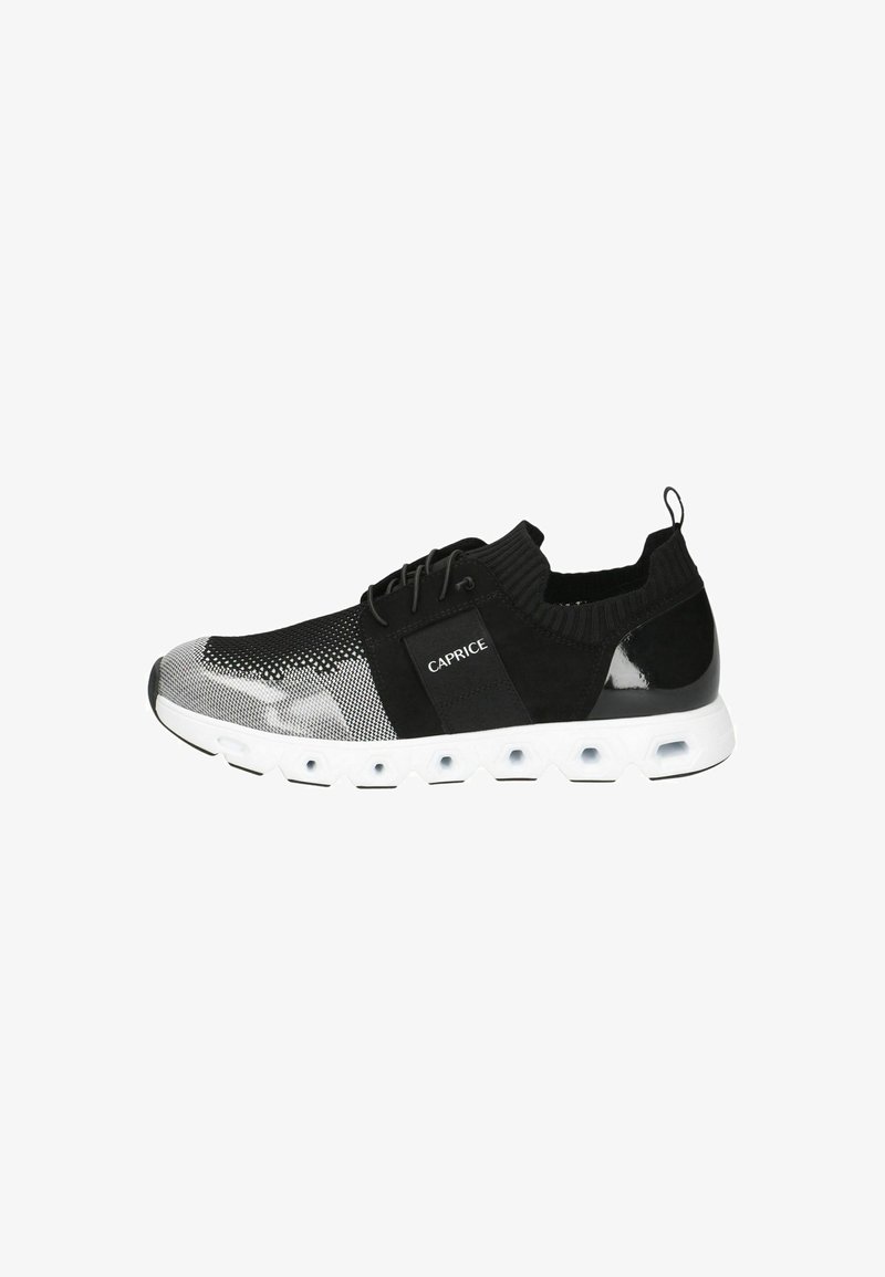 Svart och grå sneaker med övre del i mesh, mocka och glänsande detaljer, samt en vit texturerad sula med hexagonala utskärningar.