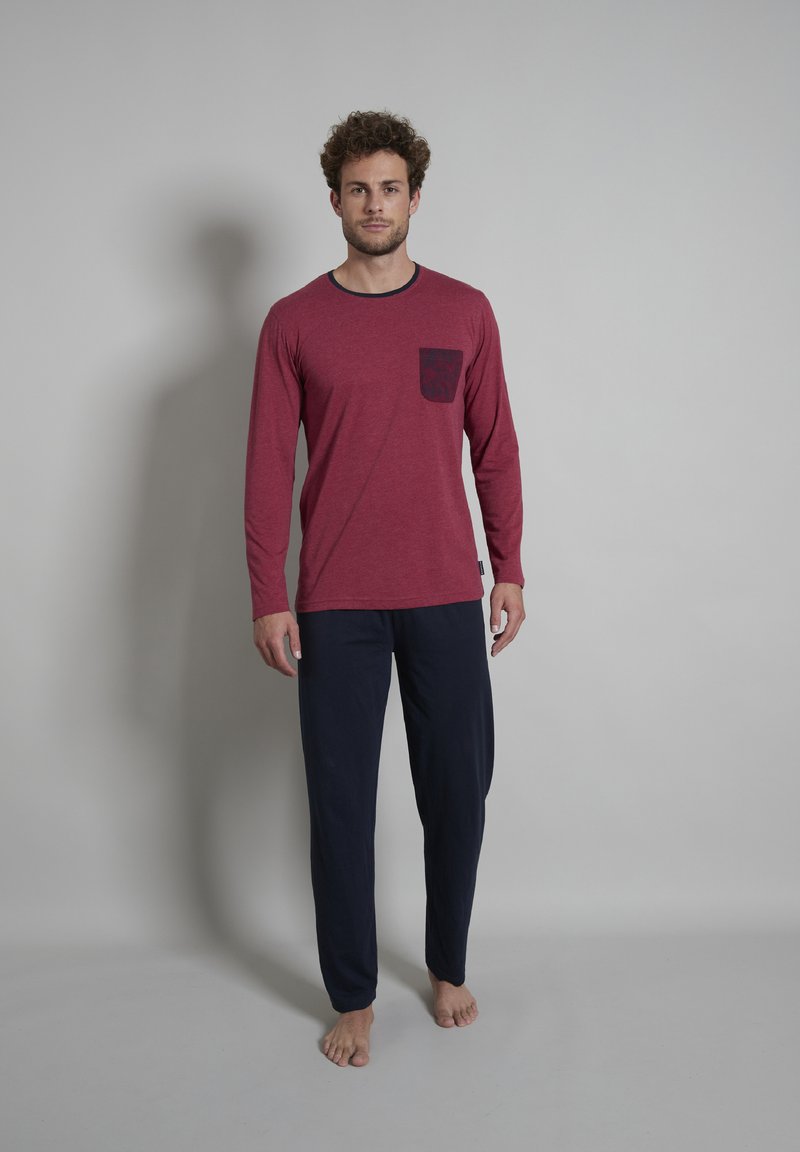 Rode langemouwen shirt met een patroon op de zak, gecombineerd met donkerblauwe, losse broek. Katoenmix stof, relaxte pasvorm en eenvoudig ontwerp.