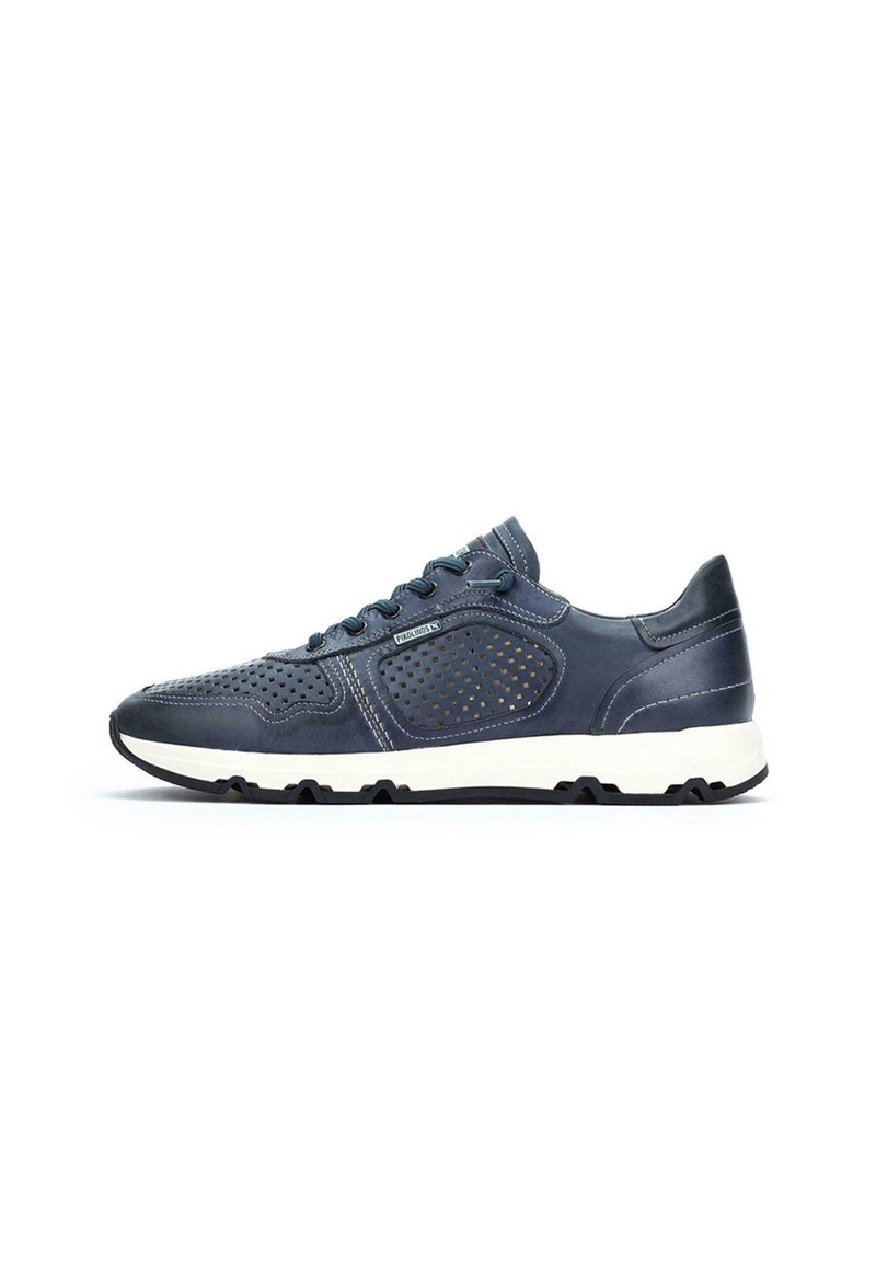 Zapatilla deportiva azul marino con parte superior de cuero perforado, suela de goma blanca y cordones azules; cuenta con un collar acolchado y costuras en contraste.