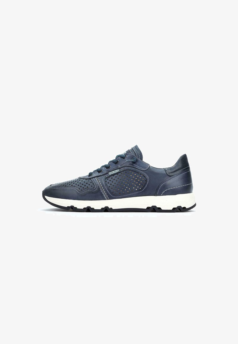Zapatilla deportiva azul marino con parte superior de cuero perforado, suela de goma blanca y cordones azules; cuenta con un collar acolchado y costuras en contraste.