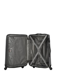 Hard-shell black suitcase with four wheels, opened to show interior compartments with mesh pocket and crisscross compression straps.