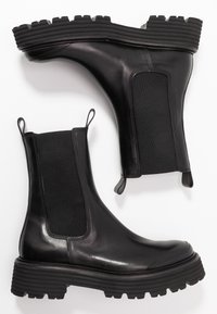 Schwarze Leder-Chelsea-Stiefel mit elastischen Seitenpaneelen, einer stabilen Gummisohle und Zugschlaufen für leichtes An- und Ausziehen. Glatte Oberfläche und strapazierfähiges Design.