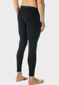 Zwarte, strakke leggings van rekbaar materiaal. Beschikt over een hoge tailleband en een gladde textuur, ontworpen voor comfort en beweging.