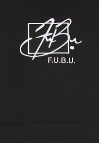 Logo FUBU blanc brodé avec écriture stylisée à l'intérieur d'un carré sur tissu noir, centré sur un vêtement.