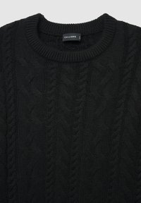 Schwarzer, gestrickter Pullover mit Zopfmuster, einem gerippten Rundhalsausschnitt und einem Etikett mit der Aufschrift "CALLIOPE" im Kragen.