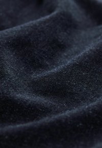 Țesătură marină cu o suprafață moale și texturată, având ondulații subtile și reflexii de lumină, indicând un material bogat și dens.