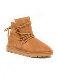 Beige Wildleder-Ankle-Boot mit runder Spitze, ausgestattet mit einem weichen Innenfutter und dekorativen Schnürsenkeln. Die flache Gummisohle sorgt für guten Halt.